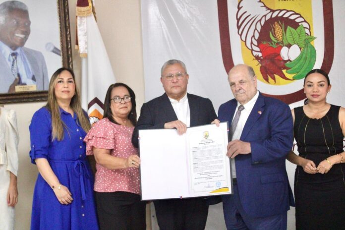 FOTO PRINCIPAL. Pedro Alvarez Pastor, esposo de Bernarda Jiménez Clemente, recibe la proclama de Hija Predilecta de Moca para su fenecida esposa, de manos del alcalde Miguel Guarocuya Cabral. (2)